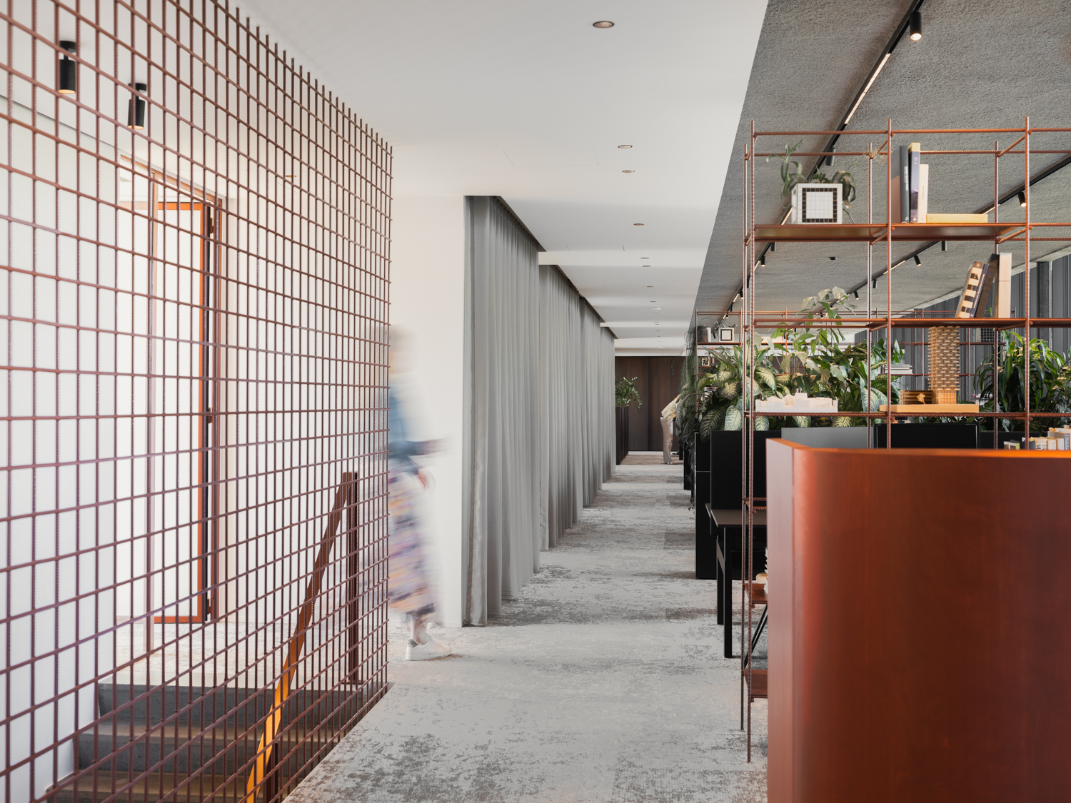 Gang in het architectuurkantoor met koperen accenten en planten